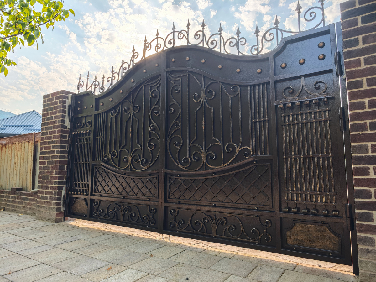 Ворота с большим количеством кованых элементов и полнотелого металла 