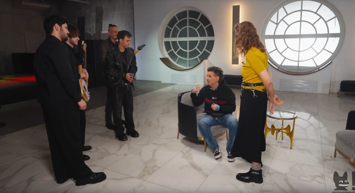 Интересная мезансцена: все стоят, он остался сидеть. / Кадр из интервью 2026 года.