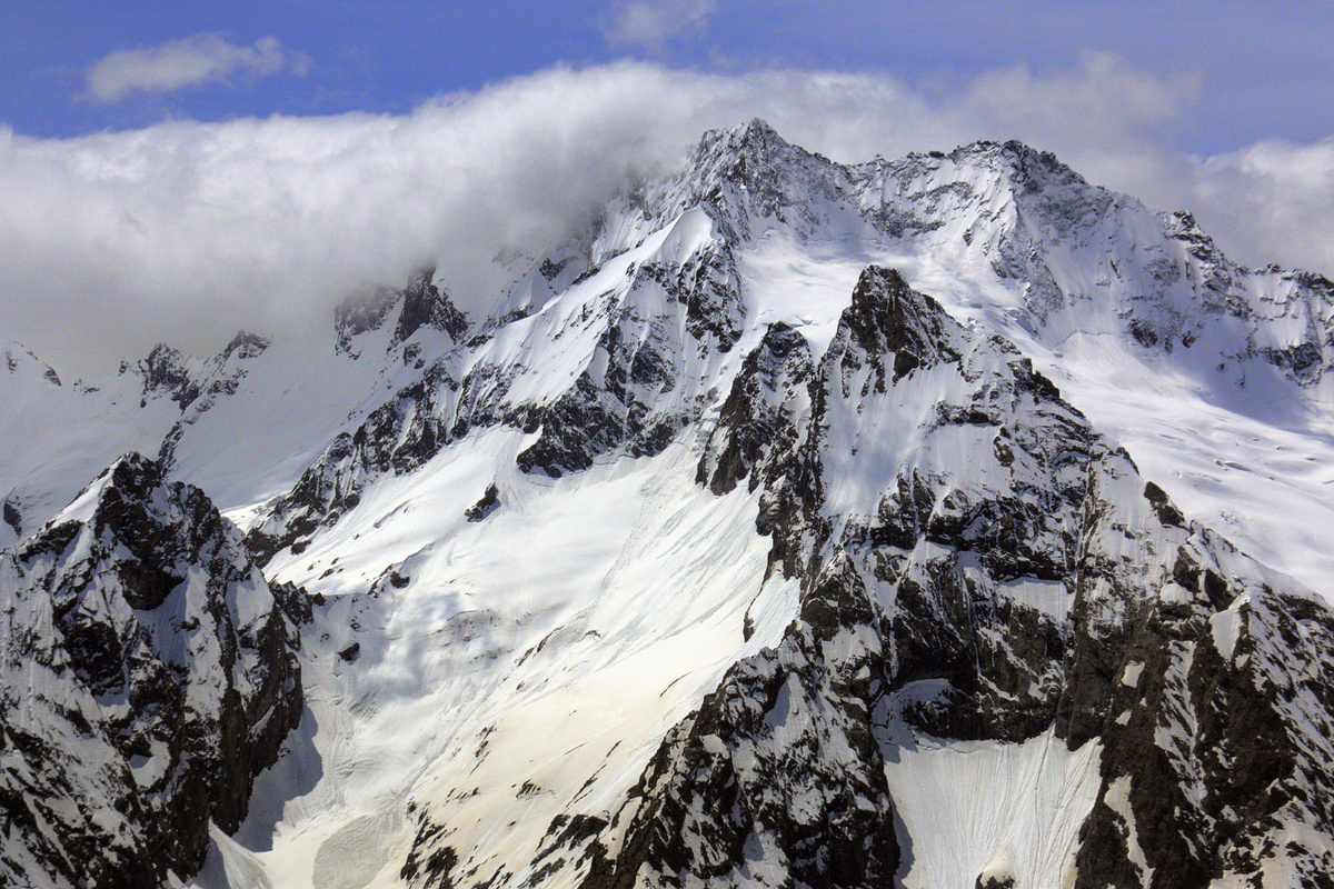 Вершина Джугутурлучата. Она то показывается, то снова прячется в облаках — как будто играет с путниками. Общественное достояние.