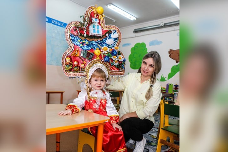    На фото Татьяны КАПЛИНОЙ маленькая Милана Працук, воспитанница младшей группы детского сада Доволенской ООШ, и её воспитатель Юлия Коврига. На Милане – результат совместной творческой работы – кокошник, посвященный символам нашей страны.