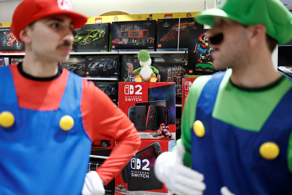 Люди в костюмах Super Mario во время начала продаж игровой консоли Nintendo Switch 2 в Париже / Benoit Tessier/Reuters   📷