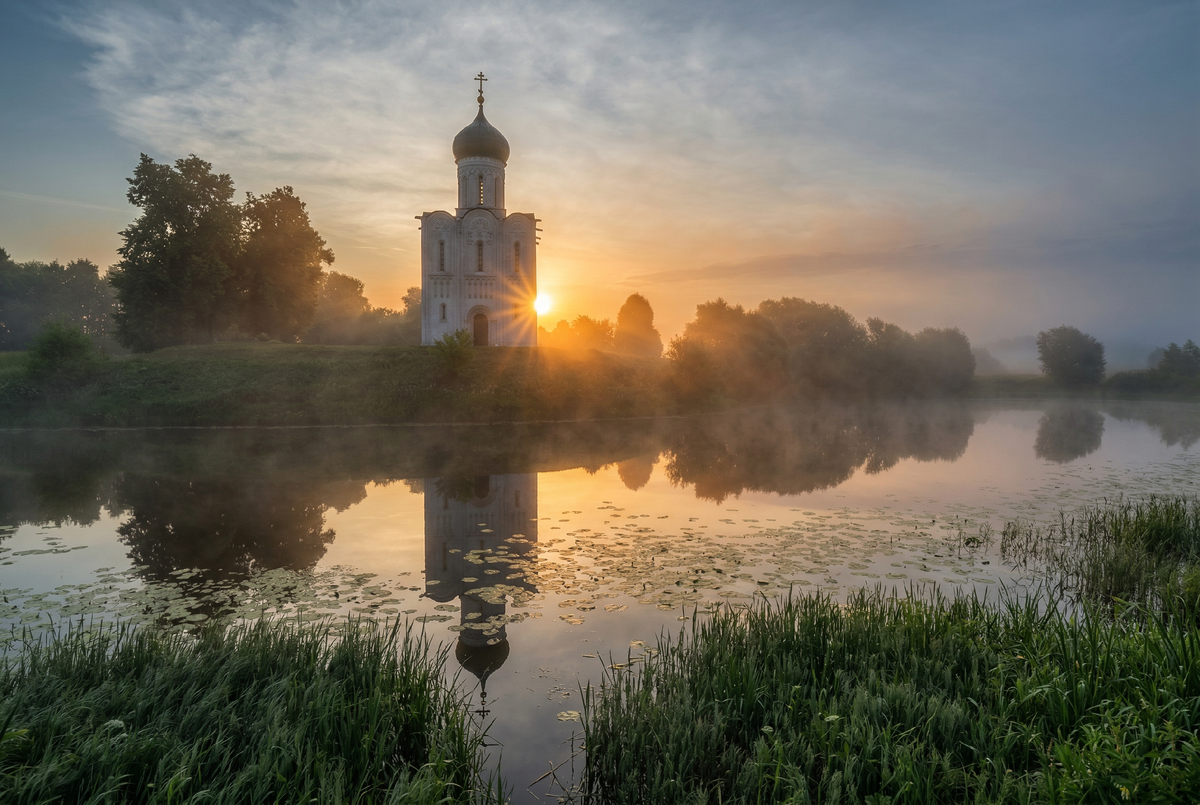 момент, когда рассвет решил добавить в историю архитектуры немного волшебства! Храм Покрова на Нерли буквально впускает солнце в свои двери, а туман и вода словно говорят: «Мы здесь ради антуража — бесплатные спецэффекты для настоящих эстетов».