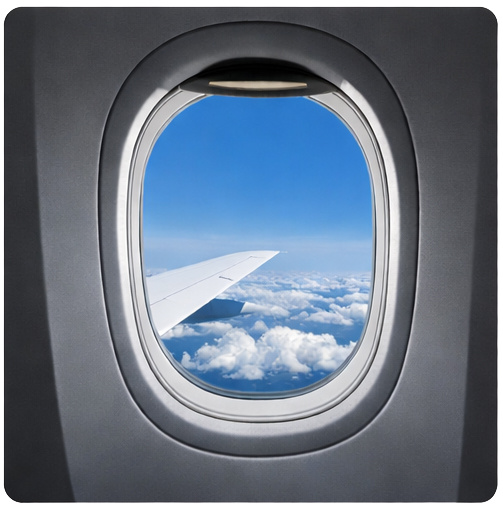 Иллюминатор пассажирского самолёта во время полёта. Окна современных лайнеров всегда имеют закруглённую форму.