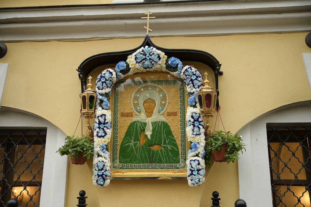 Икона на фото — находится на улице в храме Святой Матроны Московской  по адресу: Москва, Таганская 58. За стеной храма, на которой расположена эта икона ,в храме находятся Святые мощи старицы Матроны. В храме всегда очереди, но всегда можно попасть к старице и получить благословения.