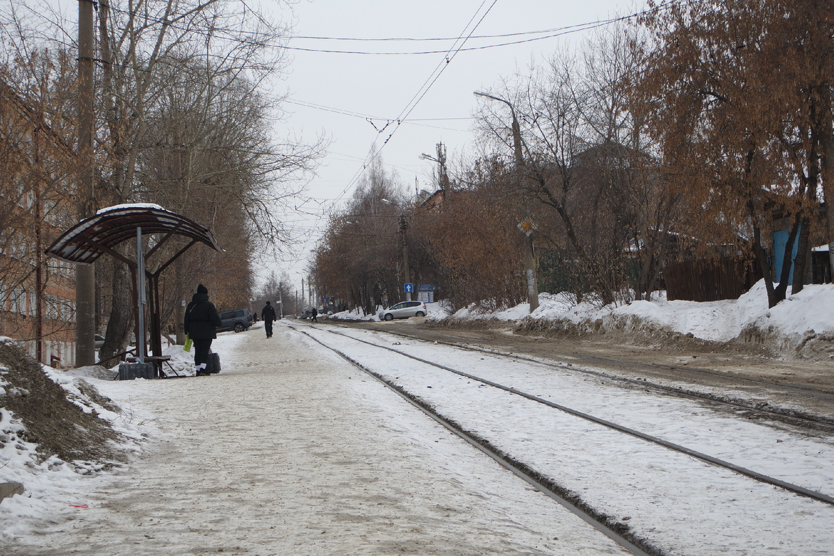 да, узкое грязноватое пространство справа от рельсов - это дорога; я же стою на пешходной части, которая представляет собой твёрдо утоптанную тропу с остатками асфальта советских времён