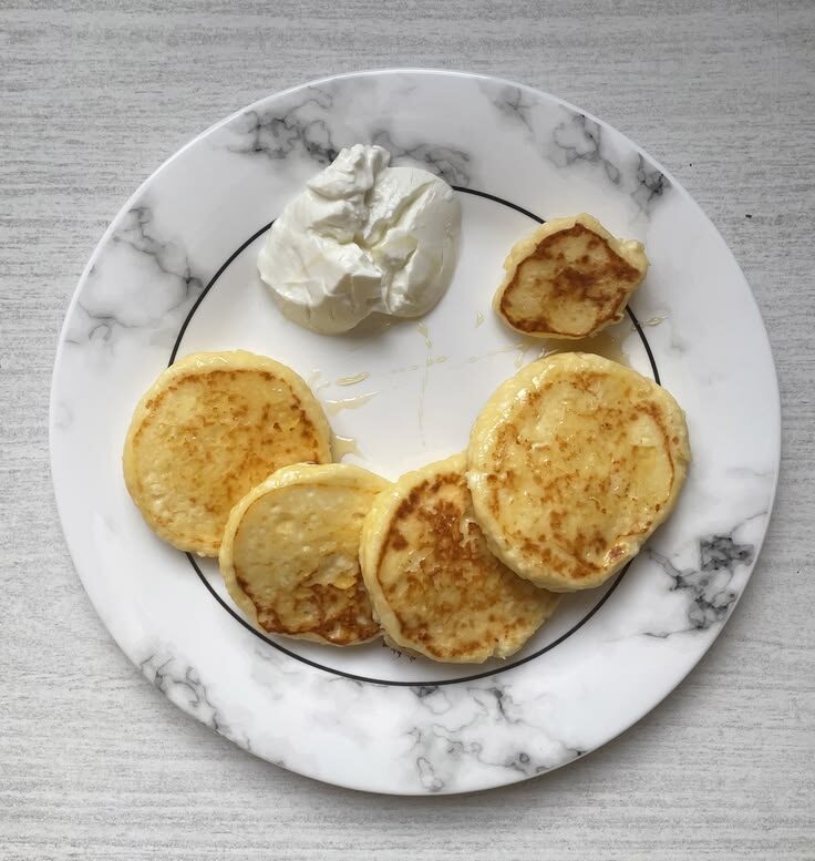 Подача сырников с рисовой мукой, медом и греческим йогуртом.