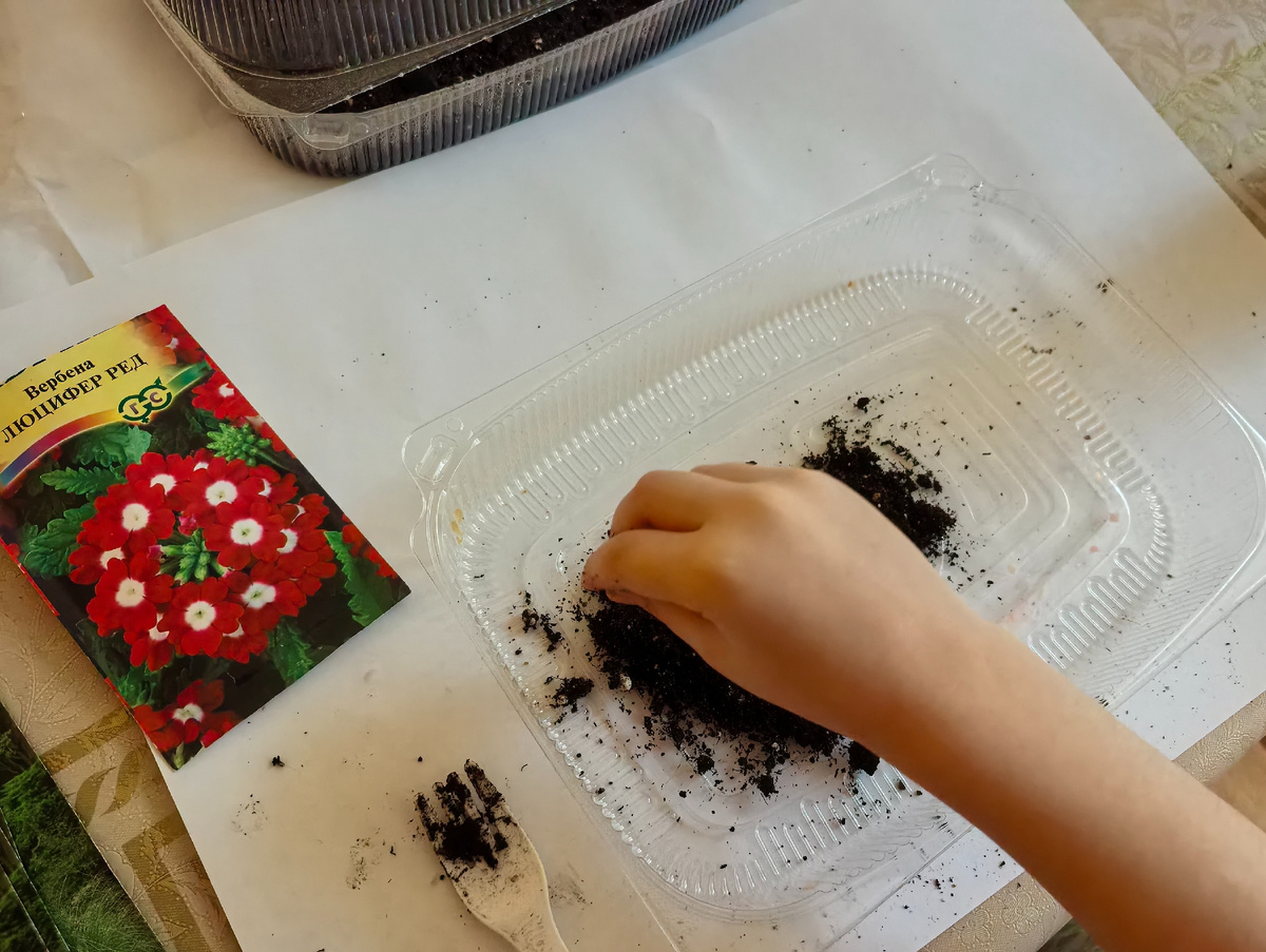 Дочка насыпает землю в плошку