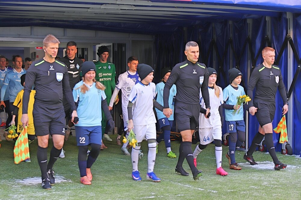 Судьи и стартовые составы команд выходят на поле в сопровождении детей.