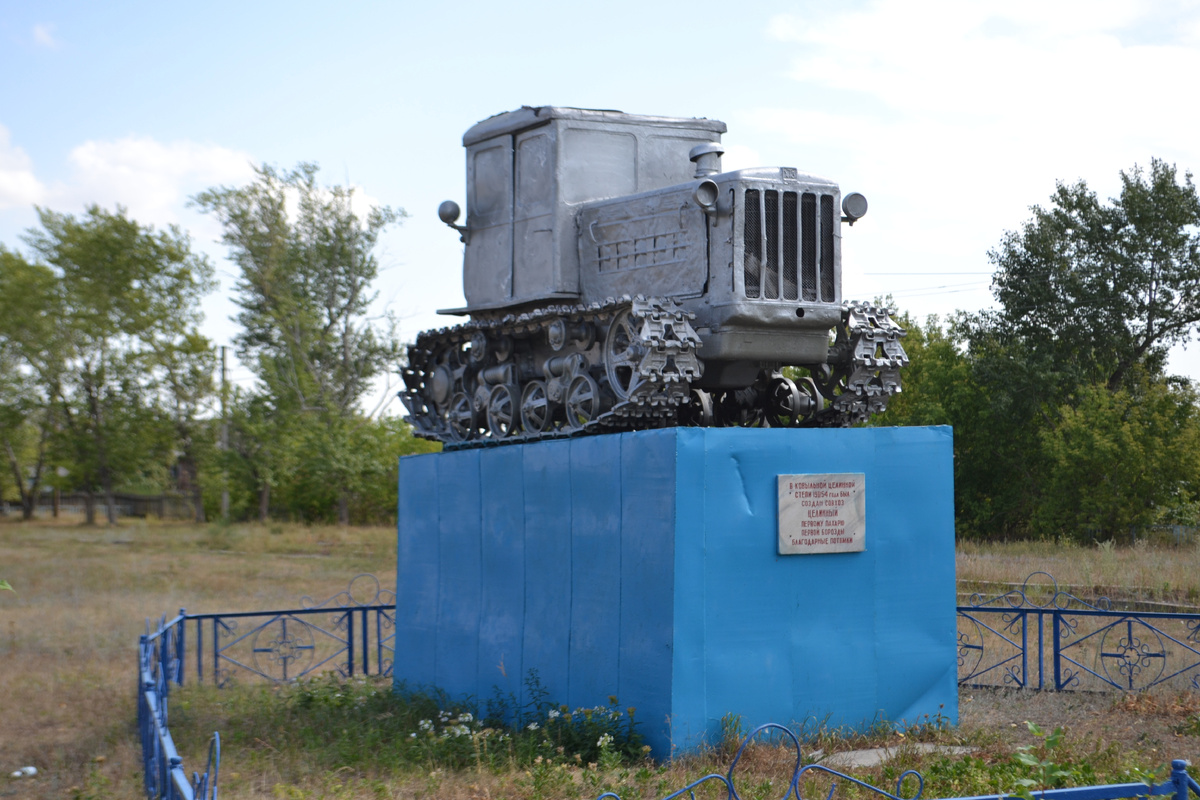 Памятник трактору в пос. Целинное. Надпись на памятнике: «В ковыльной целинной степи в 1954 году был создан совхоз Целинный. Первому пахарю первой борозды благодарные потомки»