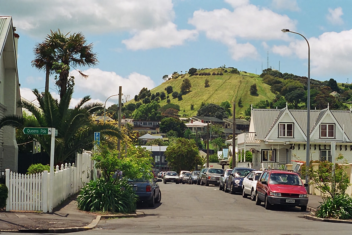 Типичная улица в одной из "деревень" Окленда. Зелёный холм на заднем плане — один из 50 вулканов в городе