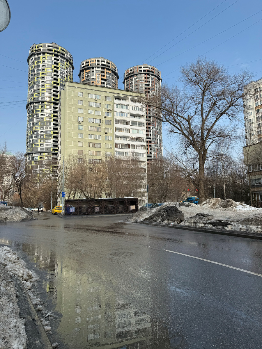 Дом №1к4 (зелёный) на улице Шверника. А ещё тут красивое отражение в луже, 2026. Фото моё.