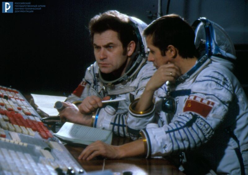 Экипаж космического корабля "Союз Т-4" – космонавты В.В. Коваленок и В.П. Савиных в скафандрах на тренировке у пульта инструкторов в ЦПК имени Ю.А. Гагарина. Звездный городок, 1981г. РГАНТД. Арх. № Д0-1618 цв.