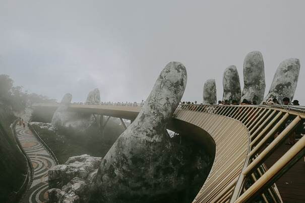 The Golden Bridge at sunrise with mist swirling around the giant hands.