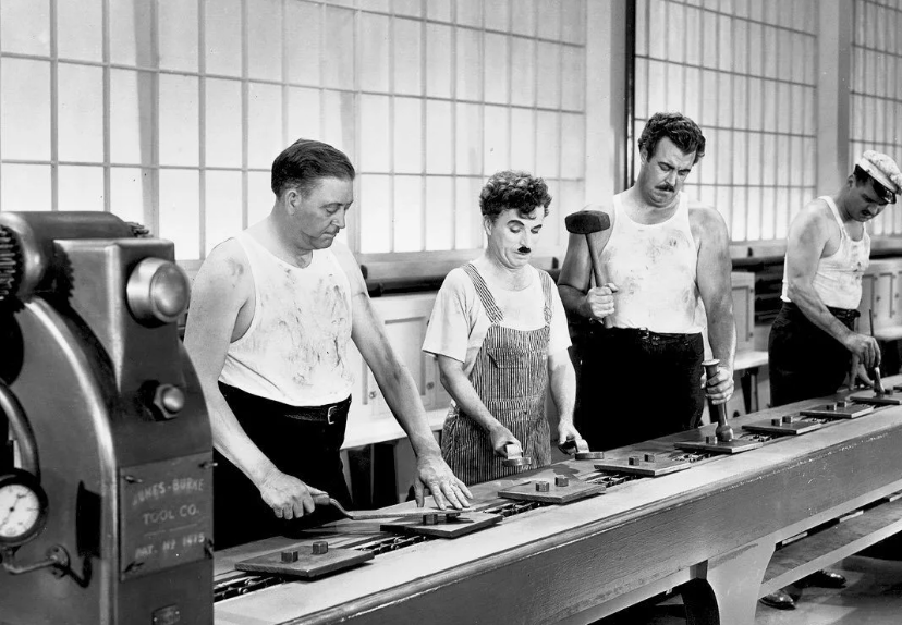 Чарли Чаплин в фильме «Новые времена» (1936). Кадр как нельзя лучше отражает суть потогонной системы Тейлора: человек становится придатком машины