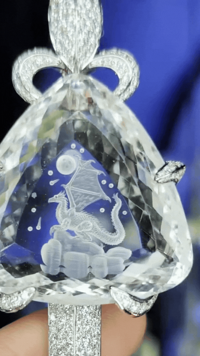 Камень украшен резьбой в виде дракона на оборотной стороне меча, а сам меч изготовлен из 18-каратного золота и бриллиантов