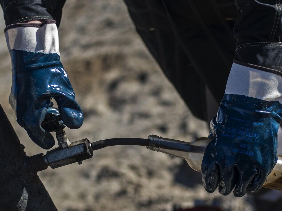    Оператор по добыче нефти и газа берет пробу жидкости из скважины | © РИА Новости / Евгений Биятов