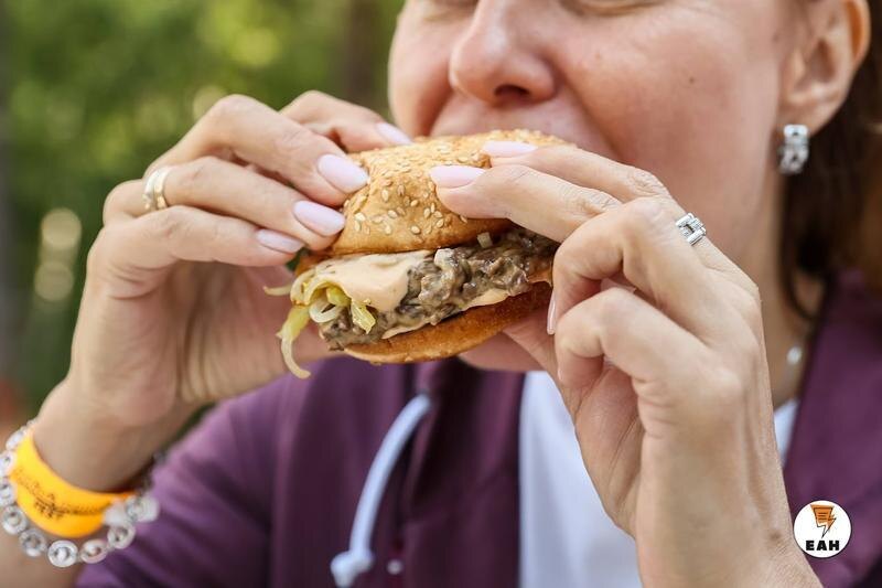    ЕАН. Женщина ест гамбургер