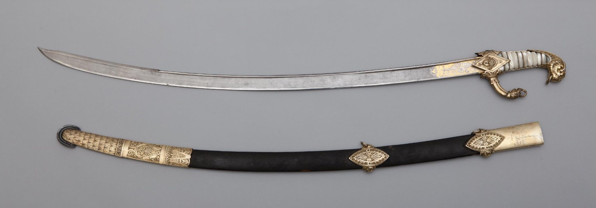 Сабля парадная Наполеона Бонапарта. Франция. Клинок — Мануфактура Клингенталя братьев Куло. Эфес, ножны и общая монтировка — Версальская оружейная мануфактура. Мастер Н. Н. Бутэ. 1801 г. Дамасская сталь, дерево, кожа, перламутр; ковка, чеканка, резьба, позолота. Длина общая — 982,0 мм, длина клинка — 845,0 мм, ширина клинка — 32,0 мм