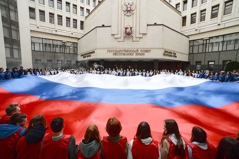    Участники акции, посвященной Дню воссоединения Крыма с Россией, перед Государственным Советом Республики Крым. / Фото: Константин Михальчевский/РИА Новости