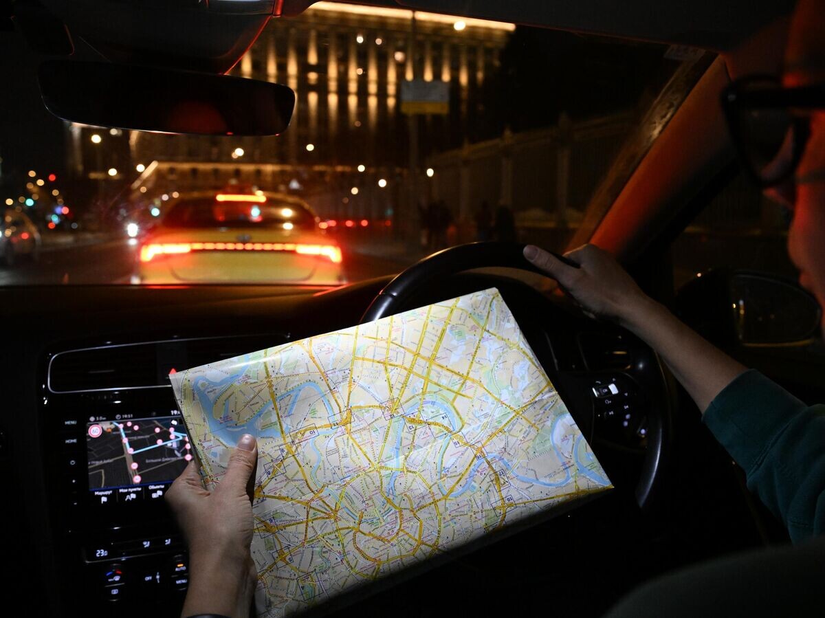    Женщина управляет автомобилем, держа в руках бумажную карту города | © РИА Новости / Максим Блинов