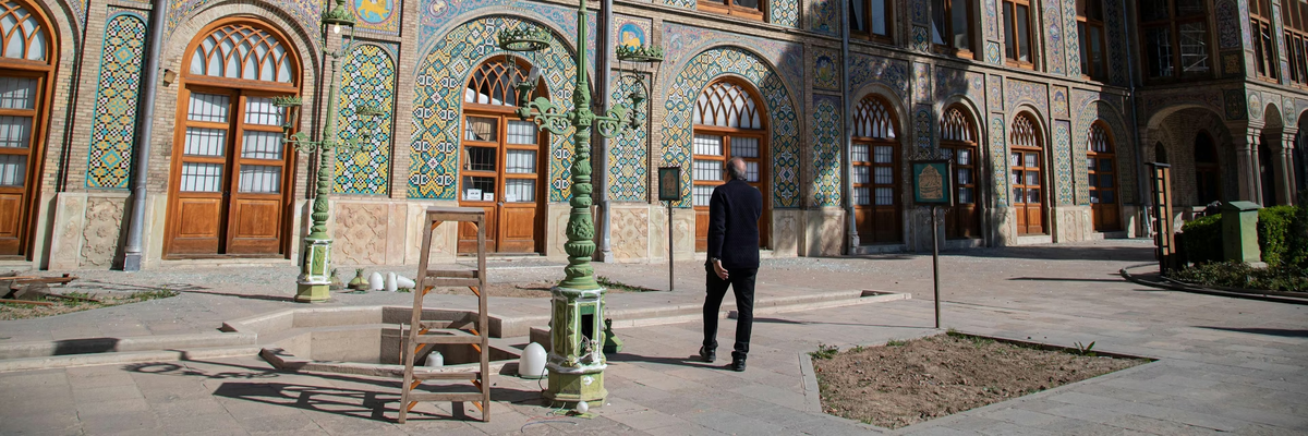 Мужчина проходит мимо обломков, разбросанных по полу дворца Голестан. UPI/Alamy Live News.