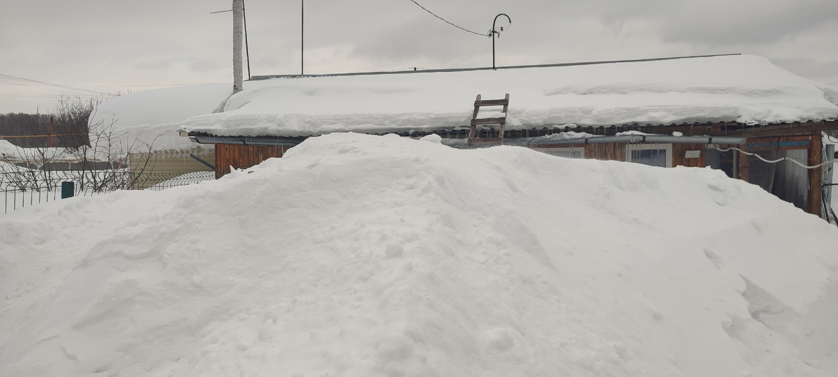 Дом из-за сугробов уже не видно