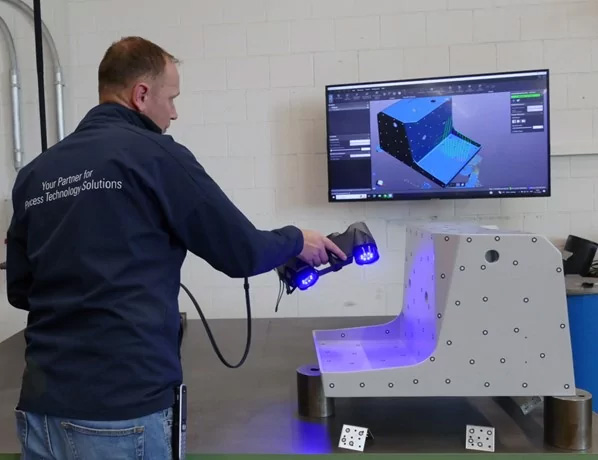 Инженер сканирует корпус машины с помощью HandySCAN 3D|BLACK Series, на заднем плане видно программное обеспечение VXinspect.