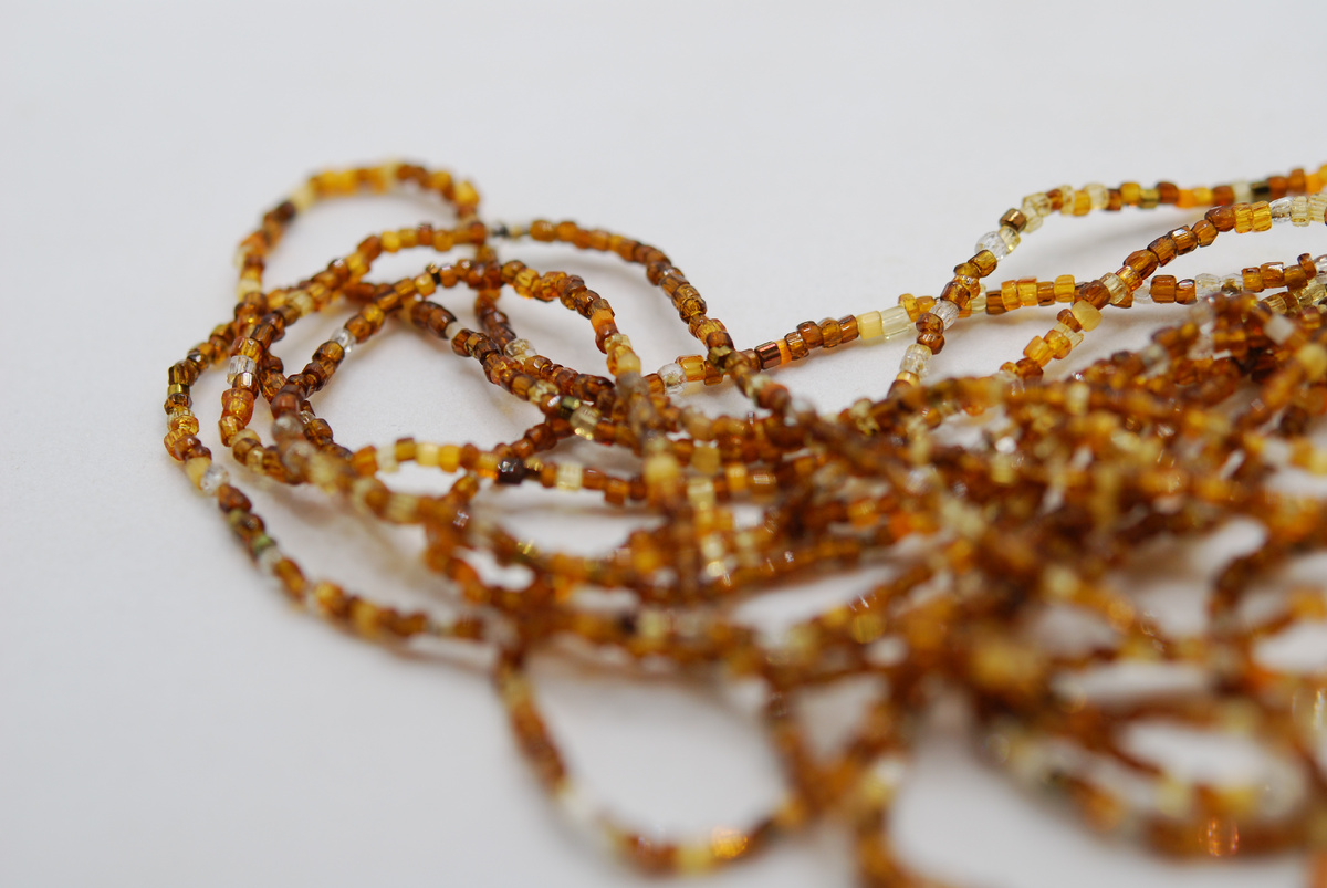 Полупрозрачная пёстрая нить бисера в коричневых оттенках.