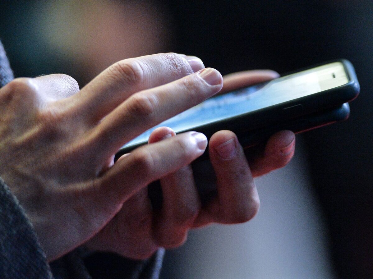    Молодой человек с телефоном в руках. Архивное фото© РИА Новости . Владимир Песня