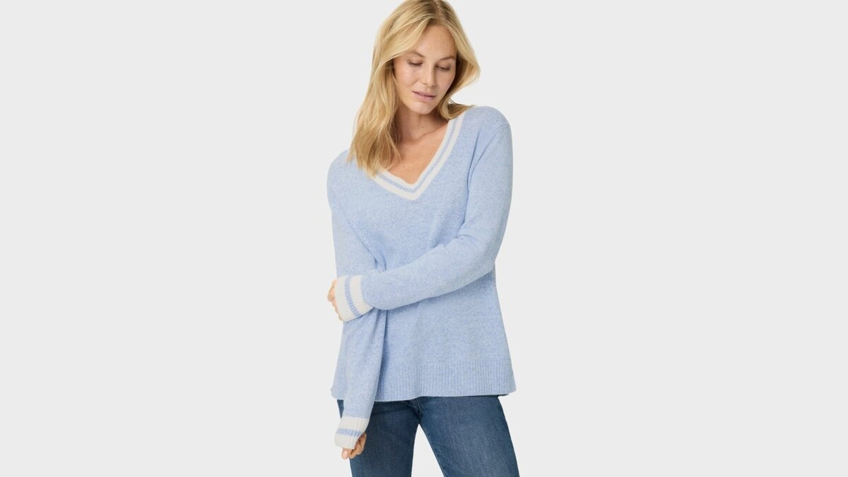 Небольшие боковые разрезы добавляют свободы движениям. Меланжевый пуловер аккуратно ложится по линии бедер, не стягивает силуэт.