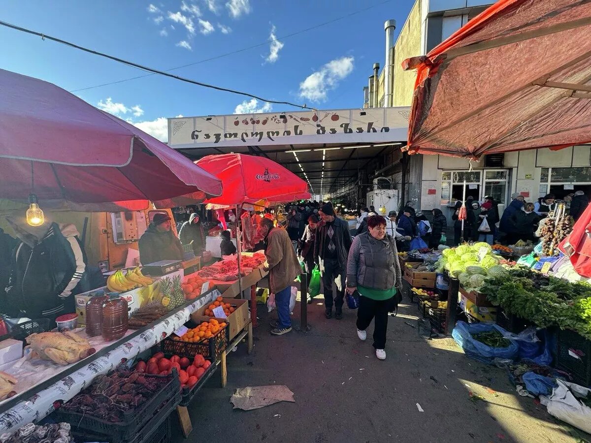 Торговля на рынке в Навтлуги мясом, сыром, овощами и фруктами перед Новым годом.