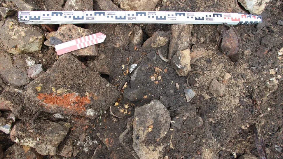 При раскопках фундамента старого дома археологи обнаружили разбитую глиняную кружку, полную монет. (Фото: Институт археологии РАН)