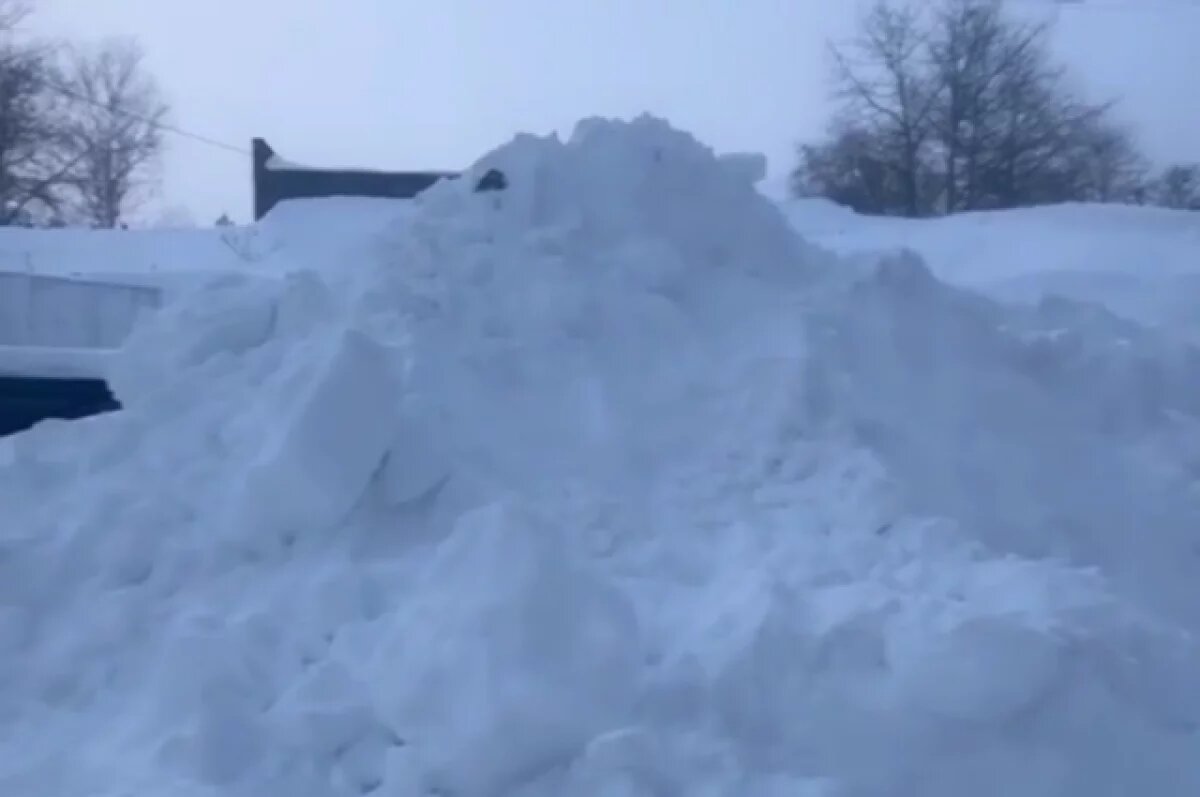    Жители Охи пожаловались на то, что двор дома утопает в сугробах и мусоре