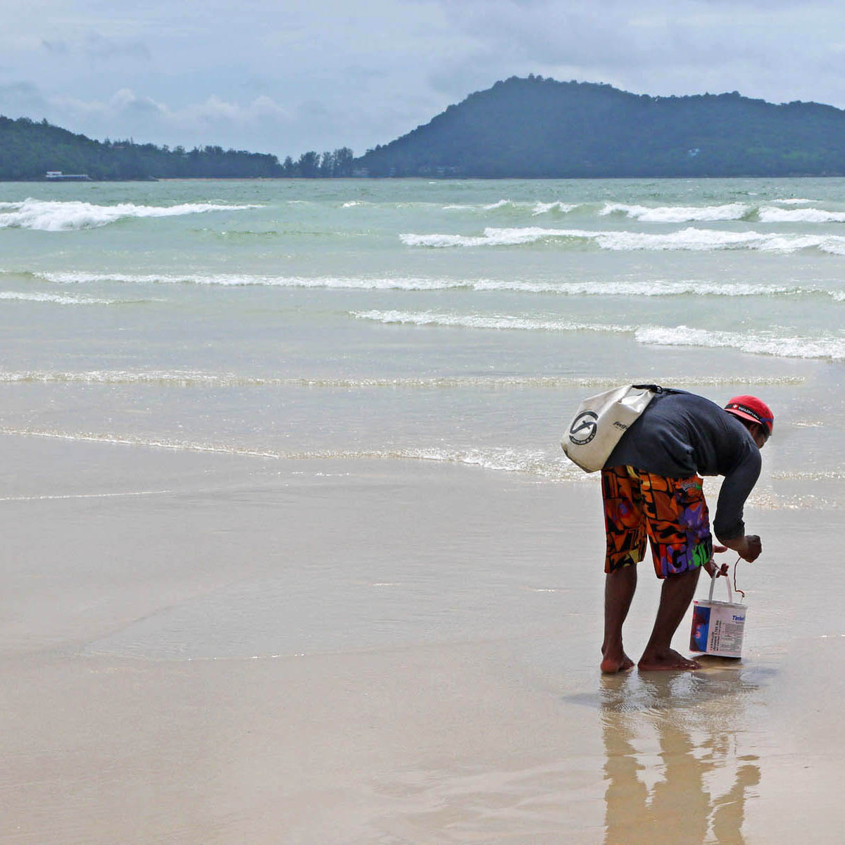 Наблюдаем, как таец достаёт длинных червей из песка на пляже в Патонге - в месте впадения канализационной реки. Фото автора.