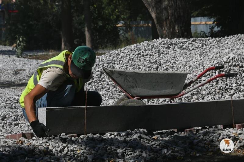    ЕАН. Рабочий рядом с кучей щебня