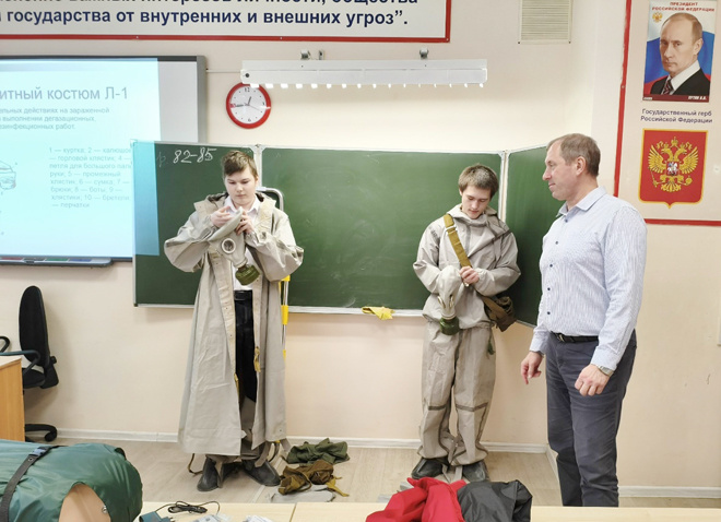 
В комплект поступившего оборудования вошли новые защитные костюмы с противогазами, которые ребята учатся надевать на уроке