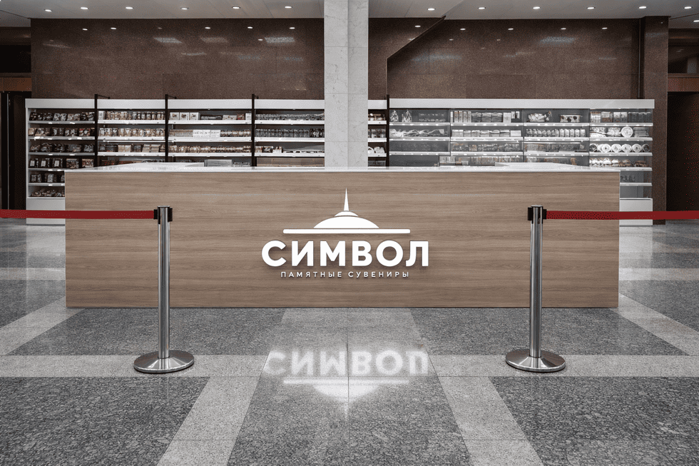 Брендирование островка сувенирного магазина с помощью световых букв и логотипа на стойке