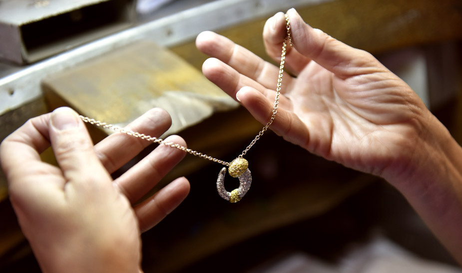 Золото украшение в руках у ювелира