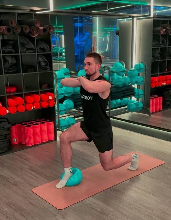 Исходное положение (ИП): Одну ногу расположите пяткой на мяче (или на высоком полупальце, при отсутствии мяча). Другую - сзади на высоком полупальце, таз — в нейтральном положении.