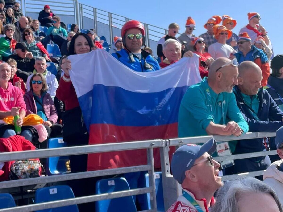   Российская делегация поддерживает атлетов на Паралимпиаде с флагом страны на трибуне | © РИА Новости / Светлана Бонопартова