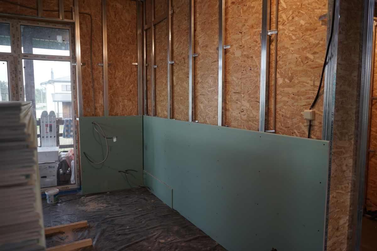 Закрываем стены гипсокартоном на первом этаже дома.