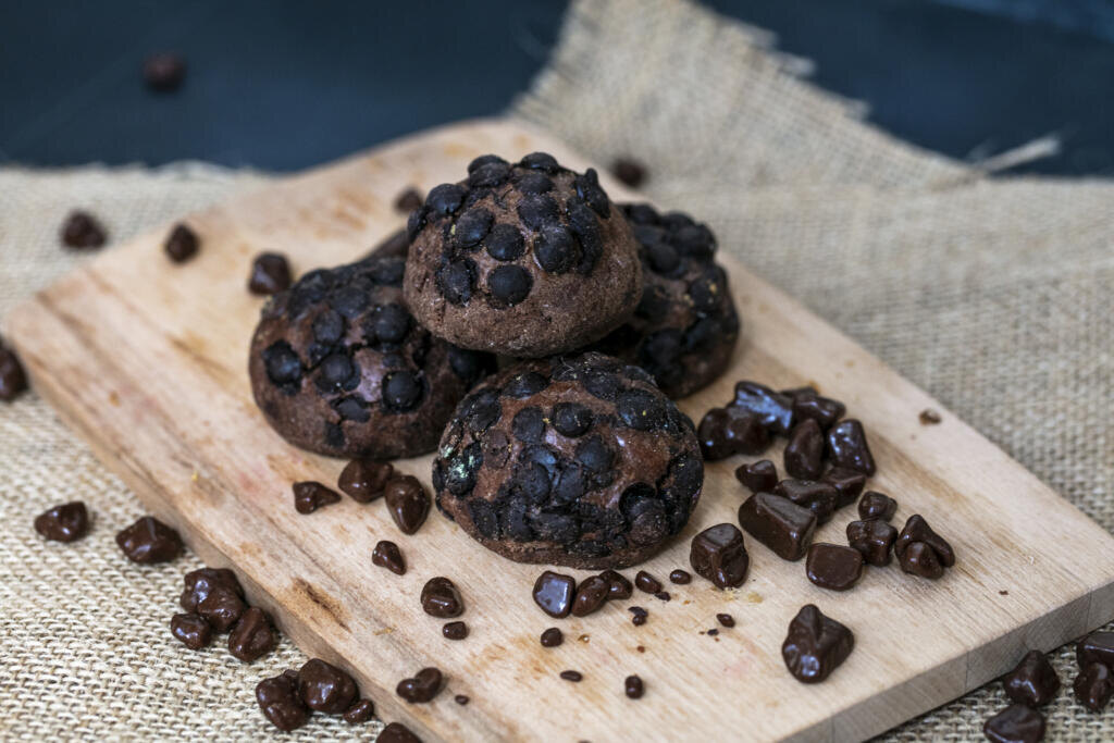    side view of cookies and chocolate on cutting board on sackcloth and blue background Журналист