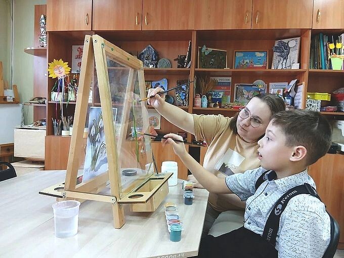 Мальчик рисует на прозрачном мольберте под руководством Дудниковой Юлии Александровны