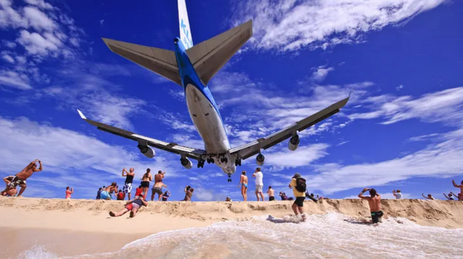 Самолет Boeing 747 авиакомпании KLM приземляется над отдыхающими на пляже в международном аэропорту Принцессы Юлианы. (visitstmaarten.com)