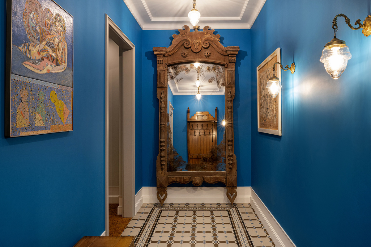 В прихожей массивное состаренное зеркало обрамлено антикварным деревянным наличником, что стало отголоском старорусского стиля