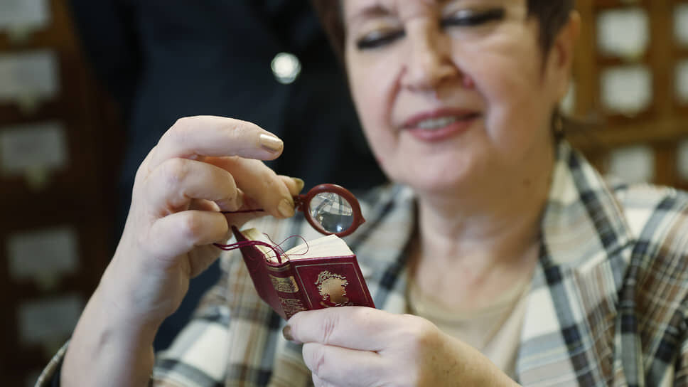 Заместитель директора библиотеки ННГУ Елена Баскакова читает микрокнигу с лупой.📷Фото: Роман Яровицын / Коммерсантъ