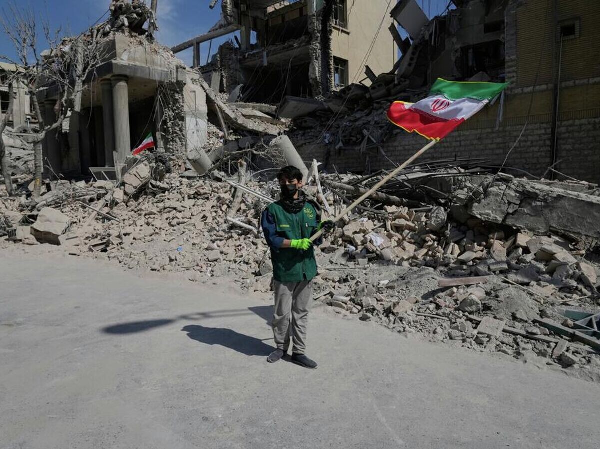    Житель Тегерана перед разрушенным после удара полицейским участком | © AP Photo / Vahid Salemi