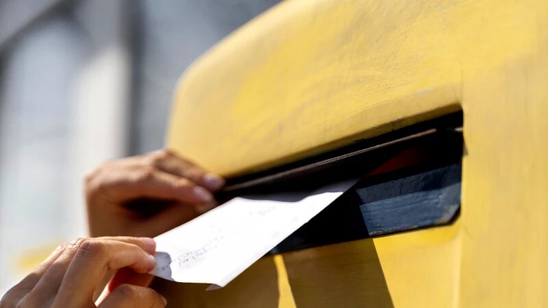     Женщина опускает письмо в почтовый ящик. Фото: ru.freepik.com, автор freepik.