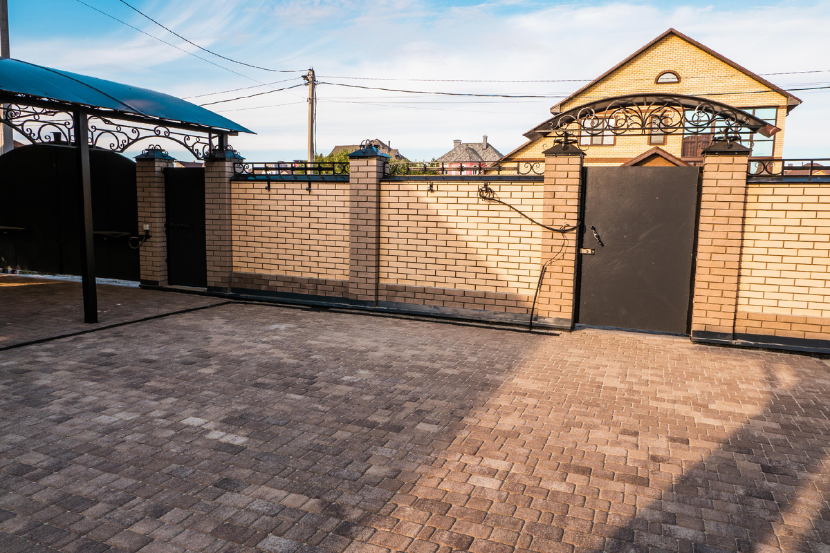 Забор из керамического кирпича и коваными элементами