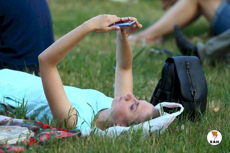    ЕАН. Девушка с телефоном на траве